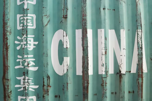 A close up of a metal shipping container with the word "China" writing on it